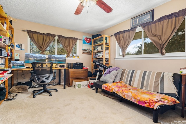 carpeted office featuring a ceiling fan, a healthy amount of sunlight, and a textured ceiling