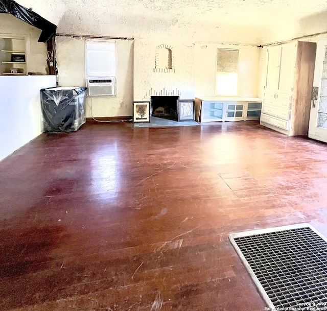 unfurnished living room with a brick fireplace and cooling unit