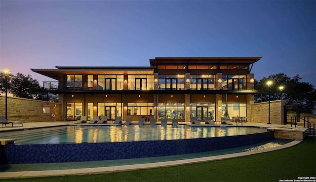 pool at dusk featuring a patio area