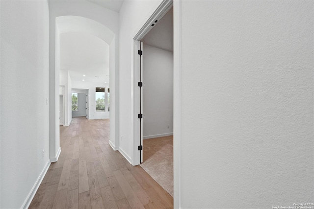 209 Teakmill Trl, San Marcos, TX 78666 - corridor featuring baseboards, arched walkways, and wood finished floors