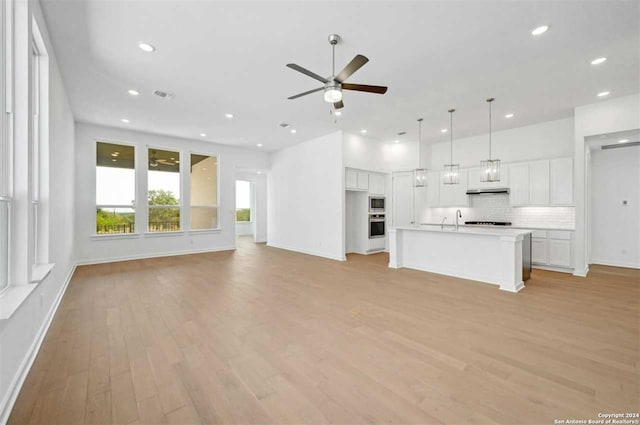 unfurnished living room with ceiling fan, light hardwood / wood-style flooring, and sink