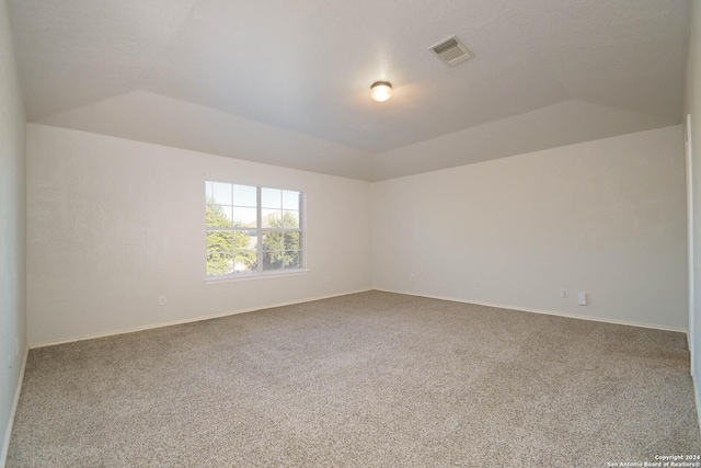 empty room featuring carpet floors and lofted ceiling