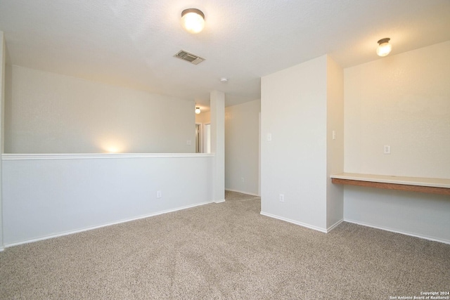 empty room with carpet floors and built in desk