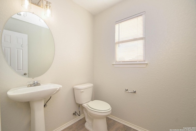 bathroom featuring wood-type flooring and toilet