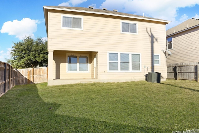 back of house with a lawn and central air condition unit