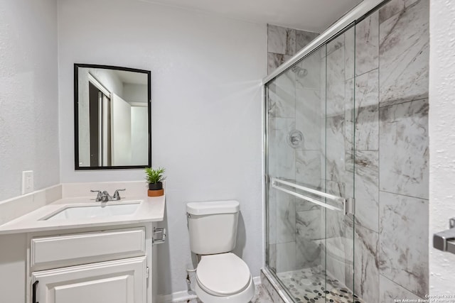 bathroom with a shower with door, vanity, and toilet