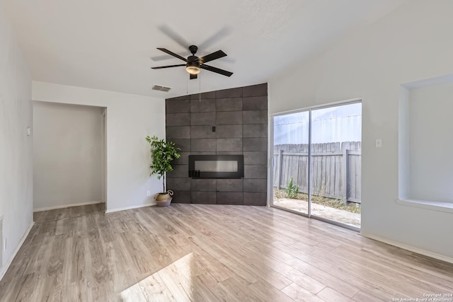 unfurnished living room featuring ceiling fan, a fireplace, high vaulted ceiling, and light hardwood / wood-style flooring