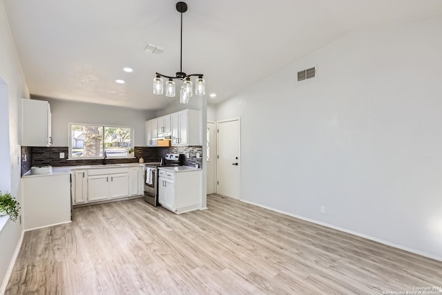 kitchen with stainless steel electric range, light hardwood / wood-style floors, white cabinetry, and vaulted ceiling