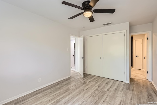 unfurnished bedroom with light wood-type flooring, a closet, and ceiling fan