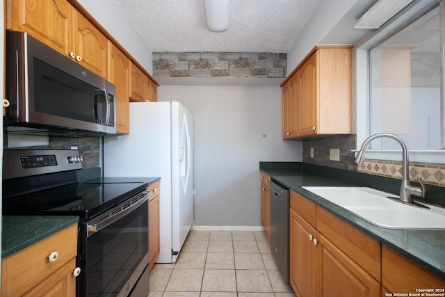 kitchen with a textured ceiling, backsplash, sink, and appliances with stainless steel finishes