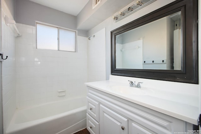 bathroom featuring vanity and tiled shower / bath