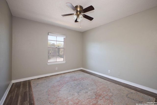 empty room with a textured ceiling, dark hardwood / wood-style floors, and ceiling fan