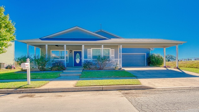 view of front of home featuring a front lawn, covered porch, and a garage