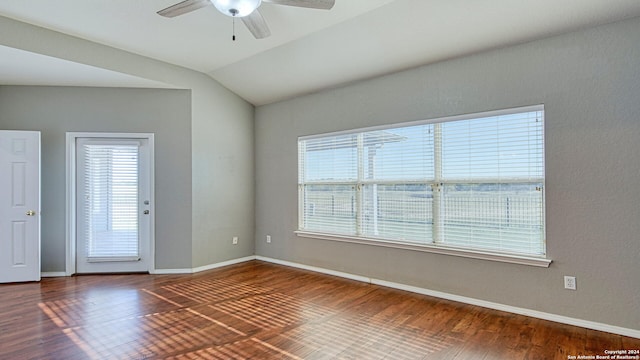 empty room with dark hardwood / wood-style floors, ceiling fan, a healthy amount of sunlight, and lofted ceiling