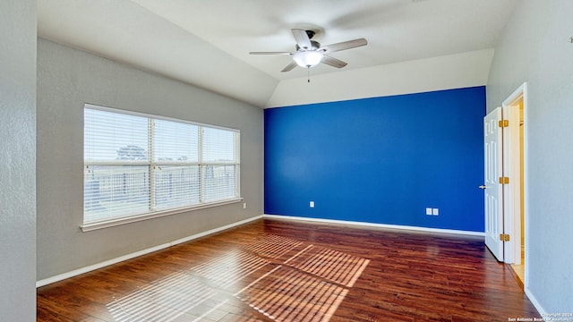 spare room with dark hardwood / wood-style floors, ceiling fan, and vaulted ceiling