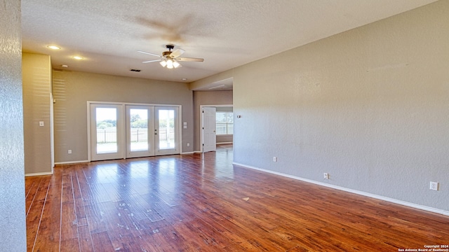 unfurnished room featuring a textured ceiling, ceiling fan, dark wood-type flooring, and french doors