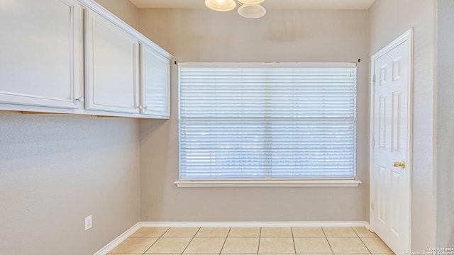 interior space with light tile patterned floors, white cabinetry, and a wealth of natural light