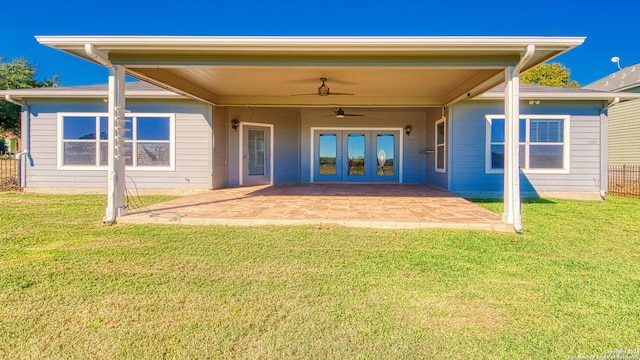 rear view of property with ceiling fan, a yard, and a patio