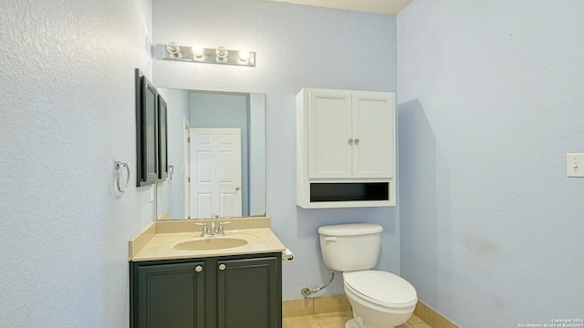 bathroom with tile patterned floors, vanity, and toilet