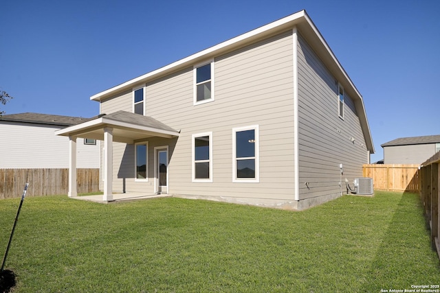 rear view of property featuring a yard and central air condition unit