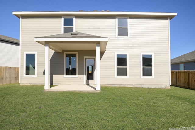 back of property with a patio and a lawn