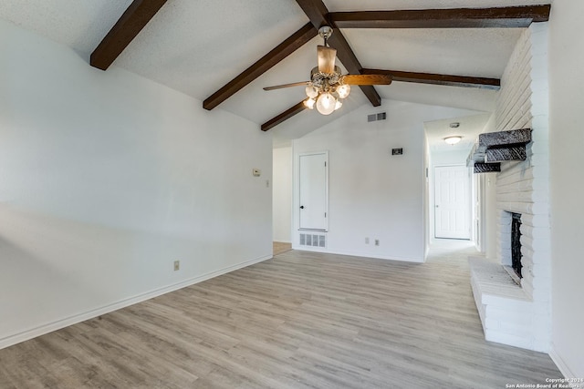 unfurnished living room with a fireplace, ceiling fan, light hardwood / wood-style flooring, and lofted ceiling with beams