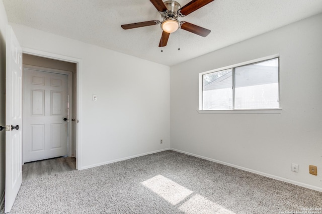 empty room with ceiling fan, carpet floors, and a textured ceiling