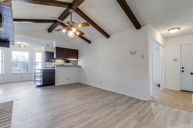 unfurnished living room with vaulted ceiling with beams, ceiling fan, light hardwood / wood-style floors, and a textured ceiling