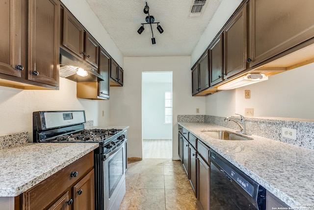 kitchen featuring gas range, light stone countertops, dishwasher, sink, and a textured ceiling