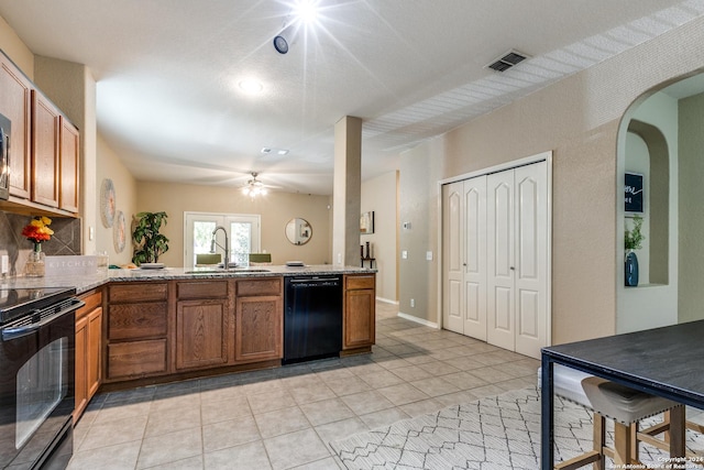 kitchen with kitchen peninsula, ceiling fan, sink, black appliances, and light tile patterned flooring