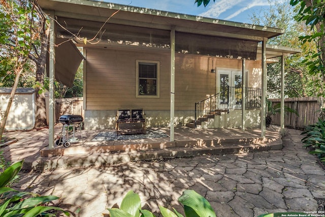 view of patio featuring french doors, a storage shed, and a grill