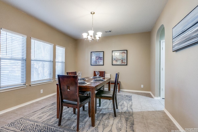 tiled dining space with an inviting chandelier