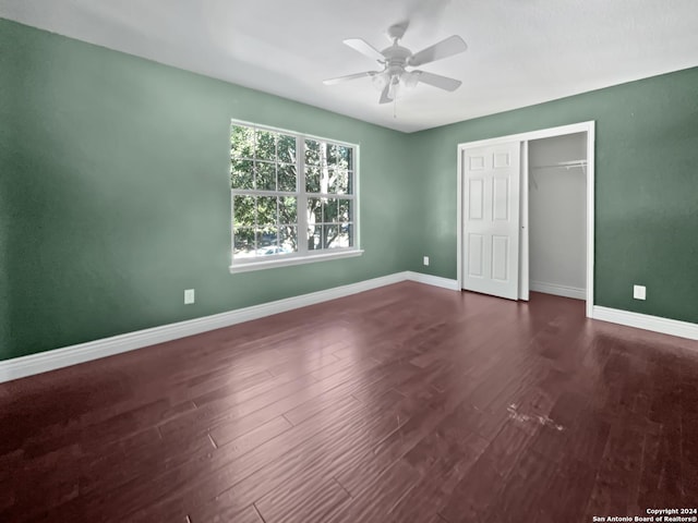 unfurnished bedroom with a closet, ceiling fan, and dark wood-type flooring