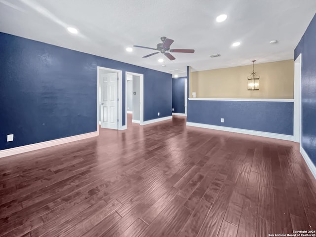 empty room featuring hardwood / wood-style floors and ceiling fan with notable chandelier