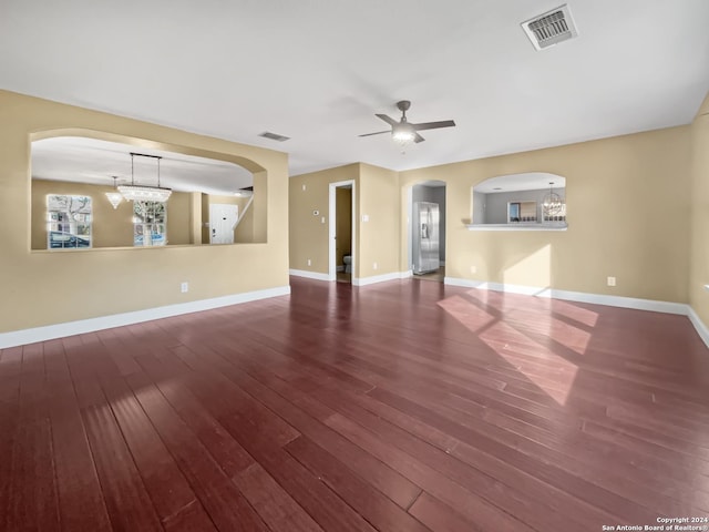 unfurnished room featuring wood-type flooring and ceiling fan with notable chandelier