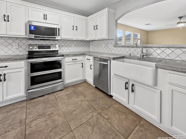 kitchen featuring white cabinets, decorative backsplash, sink, and appliances with stainless steel finishes