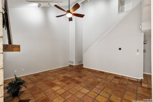 unfurnished living room featuring rail lighting, high vaulted ceiling, and ceiling fan