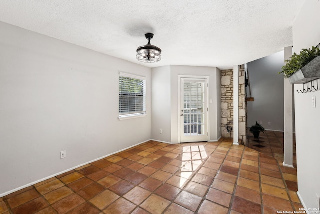 unfurnished room with a textured ceiling