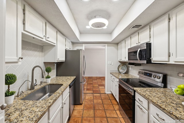 kitchen with sink, white cabinetry, stainless steel appliances, and tasteful backsplash