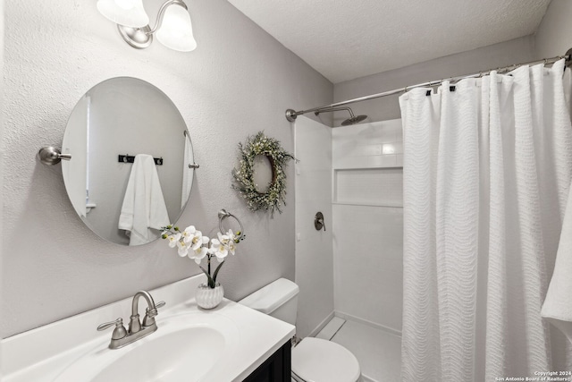 bathroom featuring toilet, vanity, a textured ceiling, and walk in shower