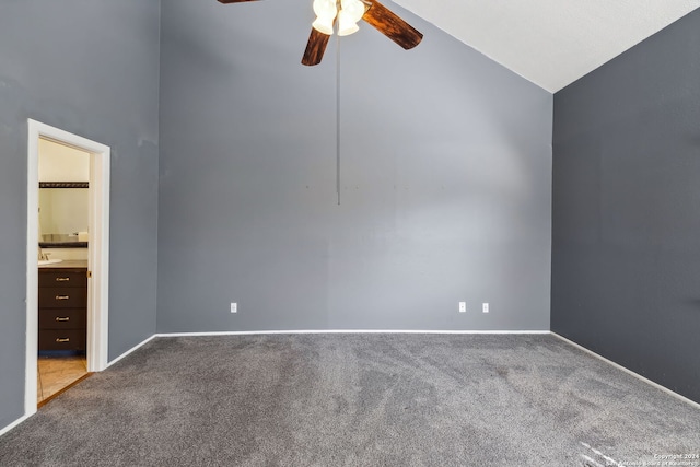 carpeted empty room with ceiling fan and high vaulted ceiling