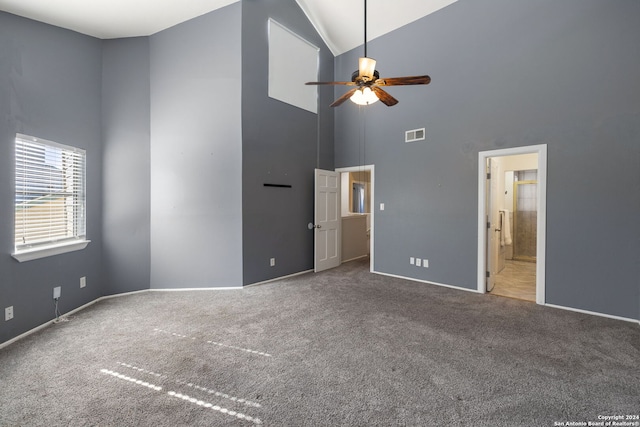 unfurnished bedroom with carpet flooring, ensuite bath, ceiling fan, and high vaulted ceiling