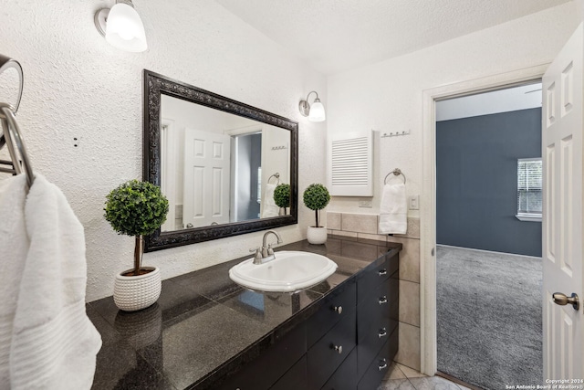 bathroom with a textured ceiling, vanity, and tile patterned floors