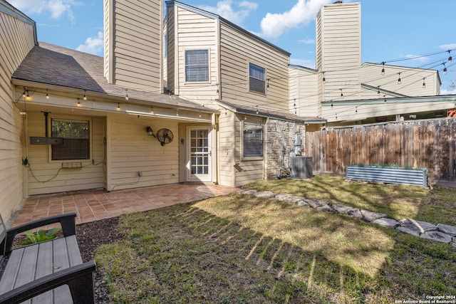 back of house featuring central AC unit, a patio area, and a yard