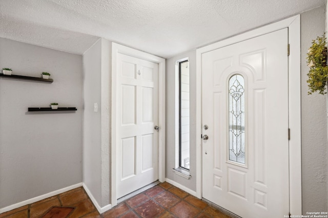 tiled entrance foyer with a textured ceiling