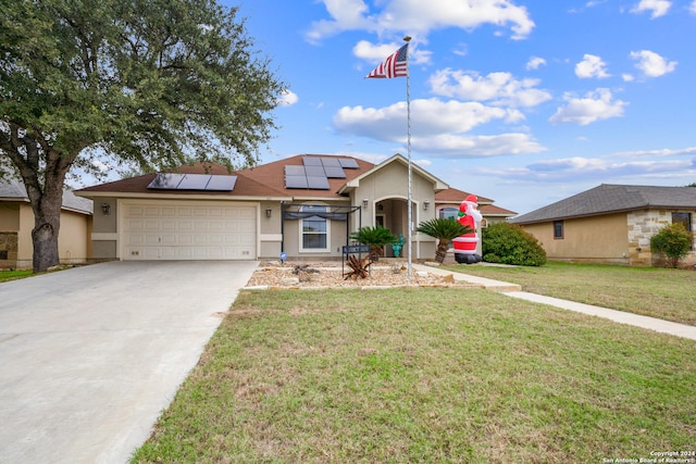 ranch-style home with solar panels, a garage, and a front lawn