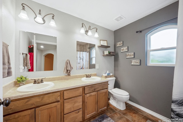 bathroom with tile patterned flooring, vanity, and toilet