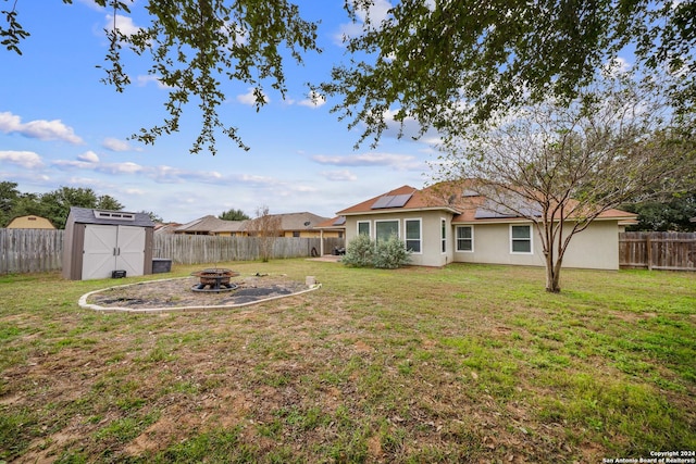 view of yard with a storage shed and an outdoor fire pit