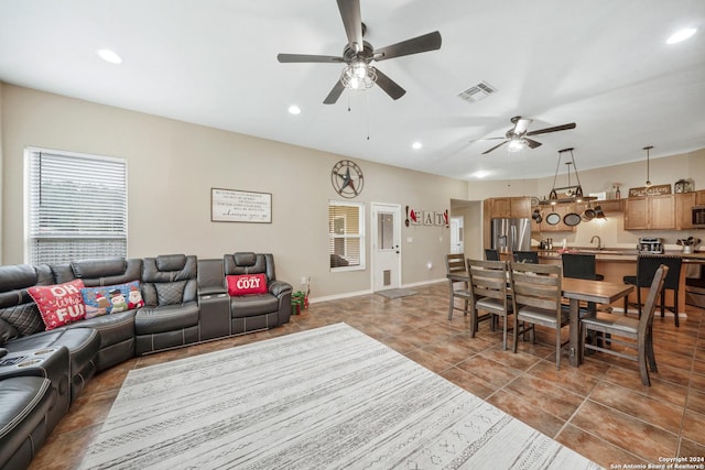 tiled living room featuring ceiling fan and sink