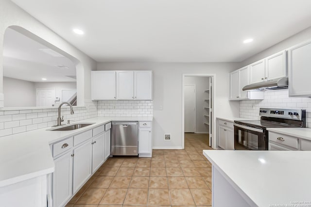 kitchen with white cabinets, sink, decorative backsplash, light tile patterned flooring, and stainless steel appliances